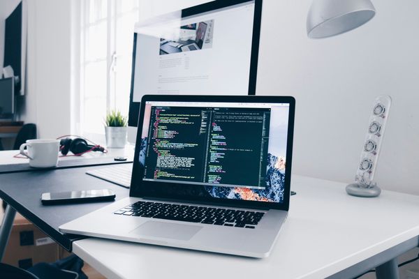Programmer writing HTML and CSS code on a laptop